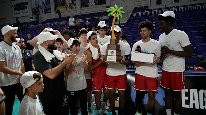 The Columbus Explorers celebrate with their City of Palms Classic championship trophy, at Suncoast Credit Union Arena in Fort Myers on Monday, Dec. 23, 2024, after their thrilling, 59-57, victory over top-ranked Montverde Academy in the final.