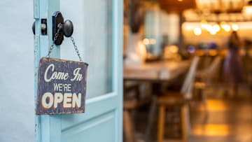 Open sign on cafe hang on door at entrance.