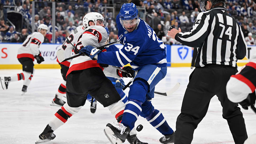 Apr 22, 2025; Toronto, Ontario, CAN;  Toronto Maple Leafs forward Auston Matthews (34) battles for the puck with Ottawa Senators forward Shane Pinto (12) in the third period in game two of the first round of the 2025 Stanley Cup Playoffs at Scotiabank Arena. Mandatory Credit: Dan Hamilton-Imagn Images