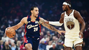 Dec 6, 2025; Cleveland, Ohio, USA; Cleveland Cavaliers guard Jaylon Tyson (20) brings the ball up court against Golden State Warriors guard Buddy Hield (7) during the first half at Rocket Arena. Mandatory Credit: Ken Blaze-Imagn Images