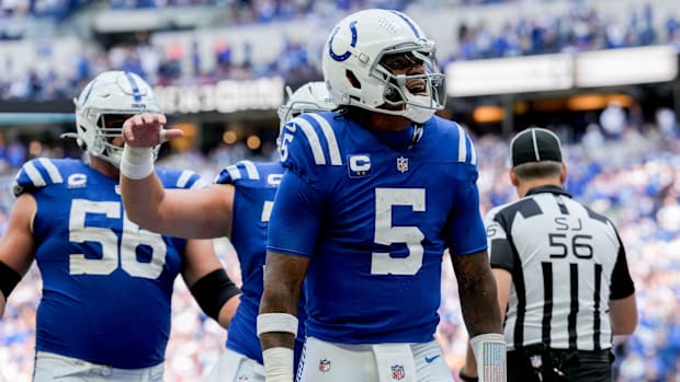 Colts QB Anthony Richardson (blue jersey; white pants/helmet) celebrates after scoring a touchdown on the ground. 