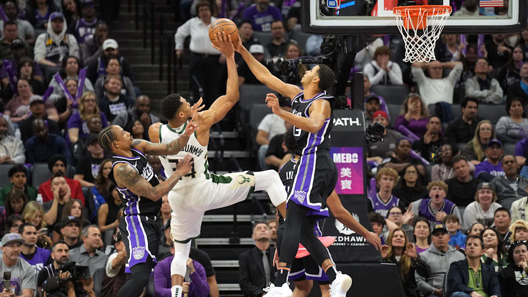 Mar 22, 2025; Sacramento, California, USA; Sacramento Kings forward Keegan Murray (right) blocks a shot by Milwaukee Bucks forward Giannis Antetokounmpo (center) as forward DeMar DeRozan (left) defends during the fourth quarter at Golden 1 Center. Mandatory Credit: Darren Yamashita-Imagn Images