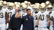 Nov 15, 2025; Pittsburgh, Pennsylvania, USA;  Notre Dame Fighting Irish head coach Marcus Freeman (middle) leads the team onto the field to play the Pittsburgh Panthers at Acrisure Stadium. Mandatory Credit: Charles LeClaire-Imagn Images
