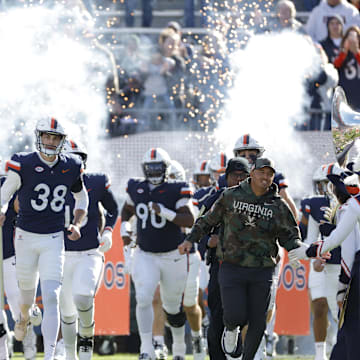 Nov 23, 2024; Charlottesville, Virginia, USA; Virginia Cavaliers head coach Tony Elliott (right) runs onto the field with players prior to their game against the Southern Methodist Mustangs at Scott Stadium. Mandatory Credit: Amber Searls-Imagn Images