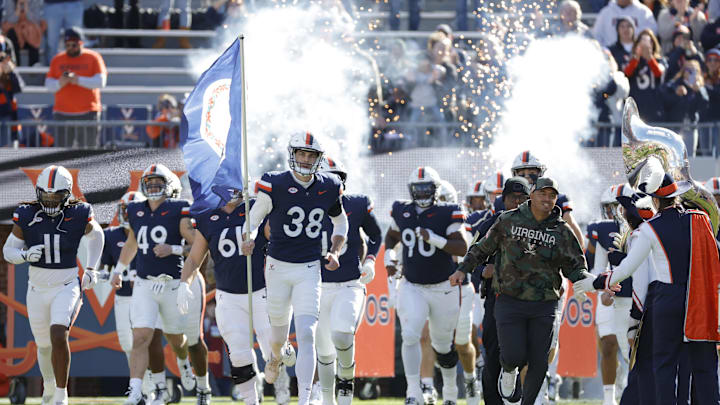 Nov 23, 2024; Charlottesville, Virginia, USA; Virginia Cavaliers head coach Tony Elliott (right) runs onto the field with players prior to their game against the Southern Methodist Mustangs at Scott Stadium. Mandatory Credit: Amber Searls-Imagn Images Nov 23, 2024; Charlottesville, Virginia, USA; Virginia Cavaliers head coach Tony Elliott (right) runs onto the field with players prior to their game against the Southern Methodist Mustangs at Scott Stadium. Mandatory Credit: Amber Searls-Imagn Images