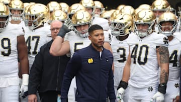Nov 15, 2025; Pittsburgh, Pennsylvania, USA;  Notre Dame Fighting Irish head coach Marcus Freeman (middle) leads the team onto the field to play the Pittsburgh Panthers at Acrisure Stadium. 