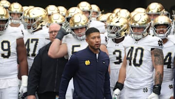 Nov 15, 2025; Pittsburgh, Pennsylvania, USA;  Notre Dame Fighting Irish head coach Marcus Freeman (middle) leads the team onto the field to play the Pittsburgh Panthers at Acrisure Stadium. Mandatory Credit: Charles LeClaire-Imagn Images