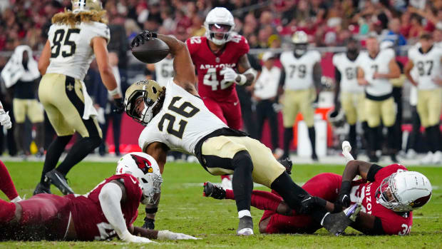 Saints running back James Robinson (26) spins for extra yards against the Cardinals defense  