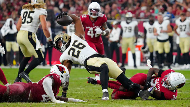 Saints running back James Robinson (26) spins for extra yards against the Cardinals 