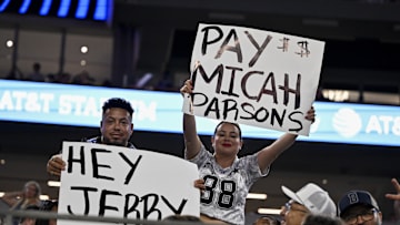 Aug 16, 2025; Arlington, Texas, USA; Dallas Cowboys fans hold up signs to owner Jerry Jones and defensive end Micah Parsons (11) during the second half of the game against the Baltimore Ravens at AT&T Stadium. Mandatory Credit: Jerome Miron-Imagn Images