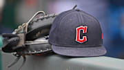 Jun 27, 2024; Kansas City, Missouri, USA; A general view a Cleveland Guardians hat and glove on the dugout railing  before a game against the Kansas City Royals at Kauffman Stadium. Mandatory Credit: Peter Aiken-Imagn Images