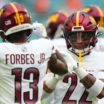 Aug 17, 2024; Miami Gardens, Florida, USA;  Washington Commanders cornerback Emmanuel Forbes Jr. (13) and safety Darrick Forrest (22) warm up before the game against the against the Miami Dolphins at Hard Rock Stadium. Mandatory Credit: Jim Rassol-Imagn Images