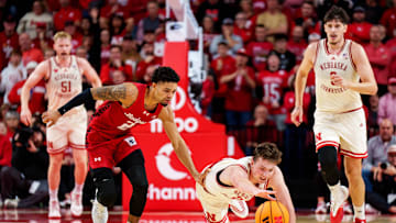 Dec 10, 2025; Lincoln, Nebraska, USA; Nebraska Cornhuskers forward Pryce Sandfort (21) dives for the ball against Wisconsin Badgers guard Nick Boyd (2) during the first half at Pinnacle Bank Arena. Mandatory Credit: Dylan Widger-Imagn Images