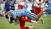 Nov 30, 2024; Chapel Hill, North Carolina, USA; North Carolina State Wolfpack running back Hollywood Smothers (20) is tacked by North Carolina Tar Heels linebacker Michael Short (30) in the first quarter at Kenan Memorial Stadium. Mandatory Credit: Bob Donnan-Imagn Images