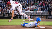Jun 17, 2025; Omaha, Neb, USA; UCLA Bruins first baseman Mulivai Levu (39) slides to third after hitting a triple against Arkansas Razorbacks third baseman Brent Iredale (10) during the ninth inning at Charles Schwab Field. Mandatory Credit: Dylan Widger-Imagn Images