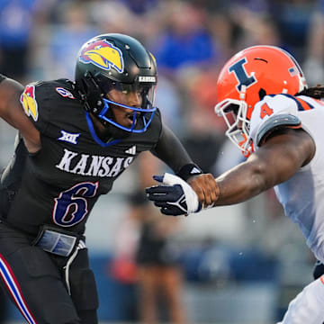 Sep 8, 2023; Lawrence, Kansas, USA; Kansas Jayhawks quarterback Jalon Daniels (6) scrambles from Illinois Fighting Illini defensive lineman Jer'Zhan Newton (4) during the first half at David Booth Kansas Memorial Stadium. Mandatory Credit: Jay Biggerstaff-Imagn Images