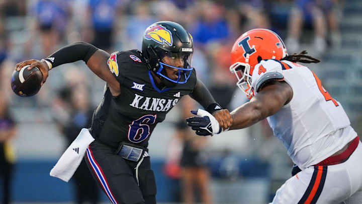 Sep 8, 2023; Lawrence, Kansas, USA; Kansas Jayhawks quarterback Jalon Daniels (6) scrambles from Illinois Fighting Illini defensive lineman Jer'Zhan Newton (4) during the first half at David Booth Kansas Memorial Stadium. Mandatory Credit: Jay Biggerstaff-Imagn Images