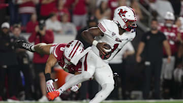 Aug 28, 2025; Madison, Wisconsin, USA;  Miami (OH) RedHawks quarterback Dequan Finn (1) tries to avoid pressure from Wisconsin Badgers linebacker Christian Alliegro (0) during the fourth quarter at Camp Randall Stadium. Mandatory Credit: Jeff Hanisch-Imagn Images