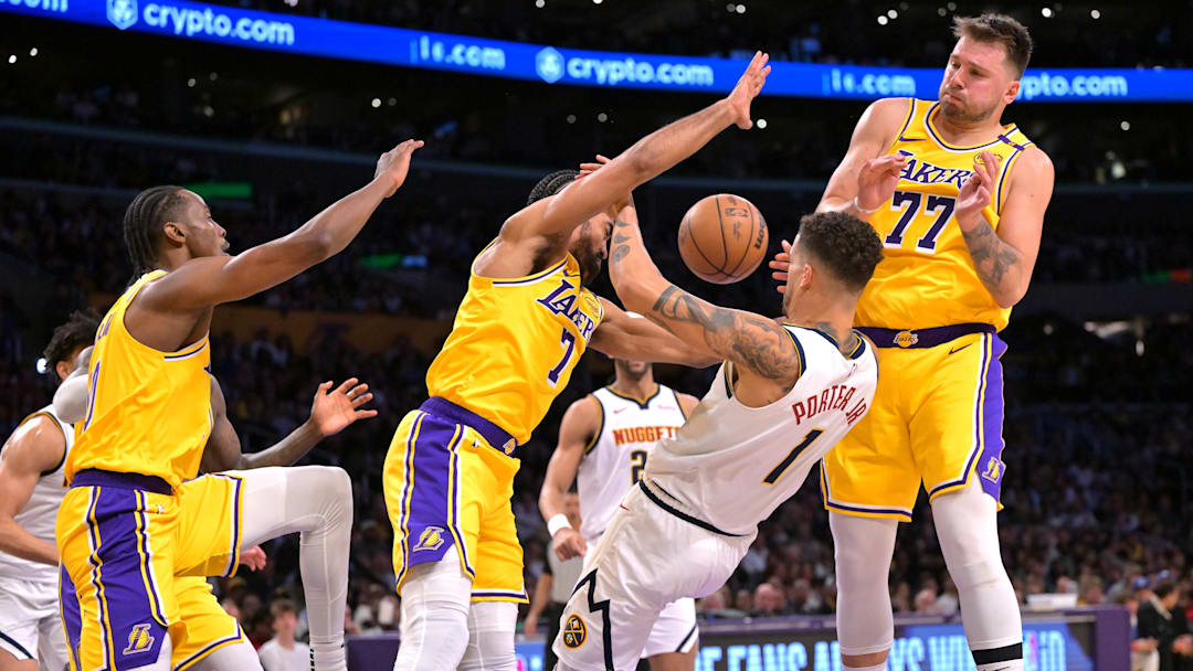 Mar 19, 2025; Los Angeles, California, USA;   Los Angeles Lakers center Christian Koloko (10), guard Gabe Vincent (7) and guard Luka Doncic (77) defend Denver Nuggets forward Michael Porter Jr. (1) in the second half at Crypto.com Arena. Mandatory Credit: Jayne Kamin-Oncea-Imagn Images