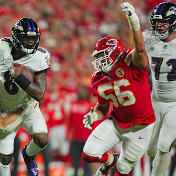 Baltimore Ravens quarterback Lamar Jackson (8) runs the ball against Kansas City Chiefs linebacker Leo Chenal (54) and defensive end George Karlaftis (56) during the second half at GEHA Field at Arrowhead Stadium. 