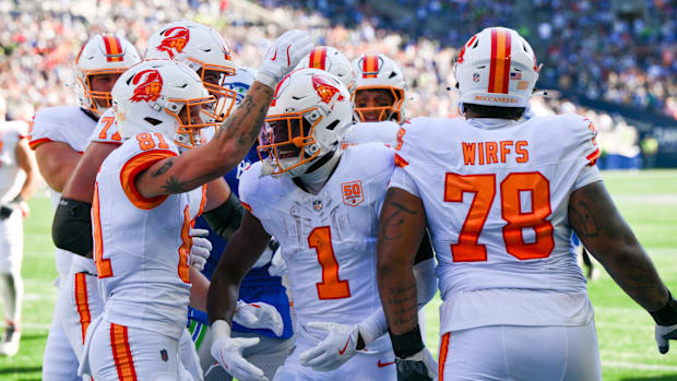Buccaneers celebrate after a touchdown in their creamsicle jerseys.