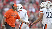 Oct 4, 2025; Louisville, Kentucky, USA; Virginia Cavaliers head coach Tony Elliott celebrates with defensive lineman Jacob Holmes (23) during the second half against the Louisville Cardinals at L&N Federal Credit Union Stadium. Virginia defeated Louisville 30-27. Mandatory Credit: Jamie Rhodes-Imagn Images