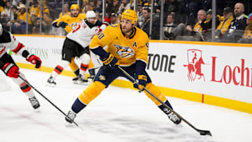  Feb 23, 2025; Nashville, Tennessee, USA;  Nashville Predators center Ryan O'Reilly (90) skates behind the net against the New Jersey Devilsduring the first half at Bridgestone Arena. Mandatory Credit: Steve Roberts-Imagn Images