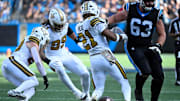 Nov 9, 2025; Charlotte, North Carolina, USA; New Orleans Saints linebacker Pete Werner (20) recovers a fumble as defensive end Chase Young (99) and safety Justin Reid (21) and Carolina Panthers center Austin Corbett (63) look on in the third quarter at Bank of America Stadium. Mandatory Credit: Bob Donnan-Imagn Images