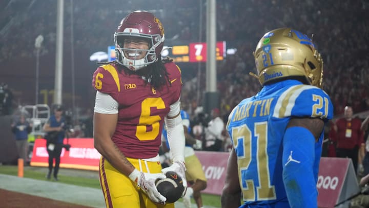 Nov 29, 2025; Los Angeles, California, USA; Southern California Trojans wide receiver Makai Lemon (6) catches a 32-yard touchdown pass against UCLA Bruins defensive back Kanye Clark (1) in the second half at United Airlines Field at Los Angeles Memorial Coliseum. Mandatory Credit: Kirby Lee-Imagn Images