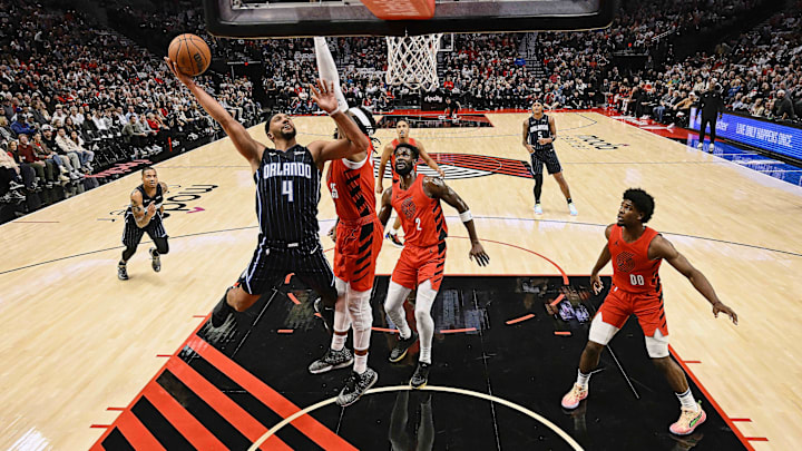 Oct 27, 2023; Portland, Oregon, USA; Orlando Magic guard Jalen Suggs (4) drives to the basket during the first half against Portland Trail Blazers center Robert Williams III (35) Deandre Ayton (2) at Moda Center. Mandatory Credit: Troy Wayrynen-Imagn Images