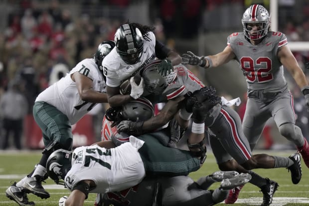 Linebacker dives into pile for tackle.