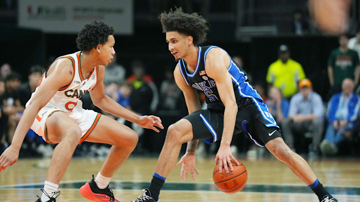 Feb 25, 2025; Coral Gables, Florida, USA;  Duke basketball guard Tyrese Proctor (5) drives up the court as Miami (Fl) Hurricanes guard Divine Ugochukwu (99) defends during the first half at Watsco Center. 
