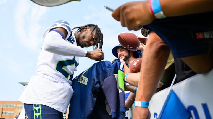 Jul 27, 2024; Renton, WA, USA; Seattle Seahawks cornerback Riq Woolen (27) signs autographs after training camp at Virginia Mason Athletic Center. Jul 27, 2024; Renton, WA, USA; Seattle Seahawks cornerback Riq Woolen (27) signs autographs after training camp at Virginia Mason Athletic Center.