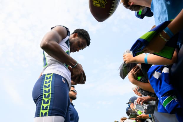 Seattle Seahawks cornerback Devon Witherspoon (21) signs autographs after training camp.