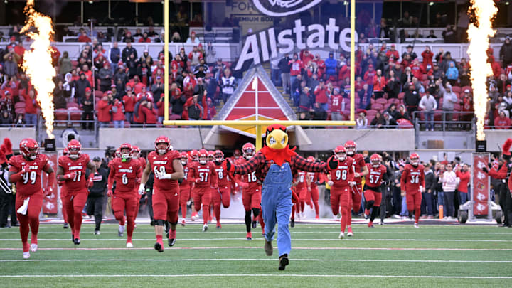 Nov 23, 2024; Louisville, Kentucky, USA; The Louisville Cardinals mascot leads the team on the field before a game against the Pittsburgh Panthers at L&N Federal Credit Union Stadium. Mandatory Credit: Jamie Rhodes-Imagn Images Nov 23, 2024; Louisville, Kentucky, USA; The Louisville Cardinals mascot leads the team on the field before a game against the Pittsburgh Panthers at L&N Federal Credit Union Stadium. Mandatory Credit: Jamie Rhodes-Imagn Images