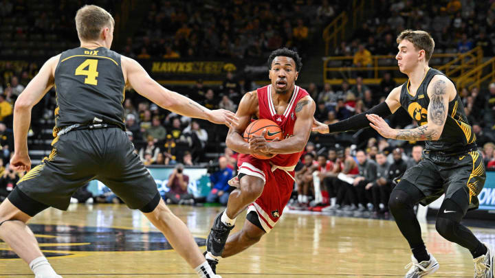 Dec 29, 2023; Iowa City, Iowa, USA; Northern Illinois Huskies guard David Coit (11) goes to the basket as Iowa Hawkeyes guard Brock Harding (2) and guard Josh Dix (4) defend during the first half at Carver-Hawkeye Arena. Mandatory Credit: Jeffrey Becker-USA TODAY Sports