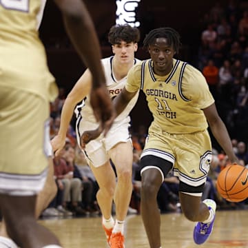 Feb 8, 2025; Charlottesville, Virginia, USA; Georgia Tech Yellow Jackets forward Baye Ndongo (11) dribbles the ball past Virginia Cavaliers forward Blake Buchanan (0) during the first half at John Paul Jones Arena. Mandatory Credit: Amber Searls-Imagn Images