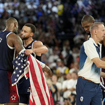 Aug 10, 2024; Paris, France; United States shooting guard Stephen Curry (4) and guard LeBron James (6) celebrate after defeating France in the men's basketball gold medal game during the Paris 2024 Olympic Summer Games at Accor Arena. Mandatory Credit: Kyle Terada-Imagn Images