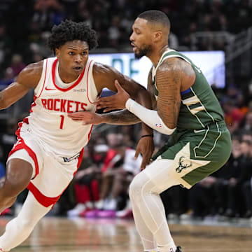 Nov 18, 2024; Milwaukee, Wisconsin, USA;  Houston Rockets guard Amen Thompson (1) drives for the basket against Milwaukee Bucks guard Damian Lillard (0) during the second quarter at Fiserv Forum. Mandatory Credit: Jeff Hanisch-Imagn Images