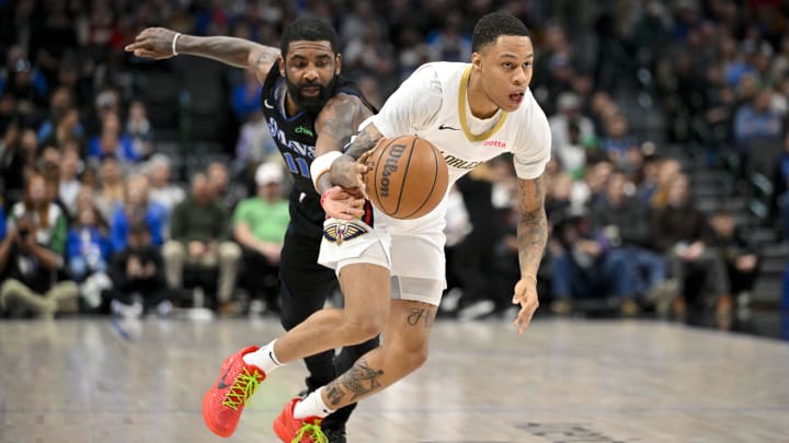 Jan 15, 2024; Dallas, Texas, USA; Dallas Mavericks guard Kyrie Irving (11) tries to steal the ball from New Orleans Pelicans guard Jordan Hawkins (24) during the second half at the American Airlines Center