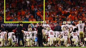 Oct 26, 2024; Miami Gardens, Florida, USA; Florida State Seminoles players take a knee around defensive back Ashlynd Barker (not pictured) after an injury against the Miami Hurricanes during the fourth quarter at Hard Rock Stadium. Mandatory Credit: Sam Navarro-Imagn Images