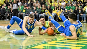 Dec 8, 2024; Eugene, Oregon, USA; Oregon Ducks guard Jackson Shelstad (3) battles for the ball against  UCLA Bruins forward Tyler Bilodeau (34) and guard Lazar Stefanovic (10) in the first half at Matthew Knight Arena.