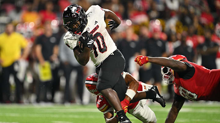 Sep 5, 2025; College Park, Maryland, USA;  Northern Illinois Huskies running back Chavon Wright (10) is tripped up by Maryland Terrapins defensive back Jalen Huskey (22) after picking up a first down in the first half at SECU Stadium. Mandatory Credit: Jamie Sabau-Imagn Images