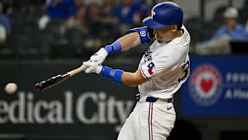 May 2, 2024; Arlington, Texas, USA; Texas Rangers center fielder Evan Carter (32) hits a singles and drives in a run against the Washington Nationals during the second inning at Globe Life Field. Mandatory Credit: Jerome Miron-Imagn Images
