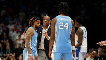 North Carolina Tar Heels head coach Hubert Davis talks with guard RJ Davis (4) as forward Jae'Lyn Withers (24) 