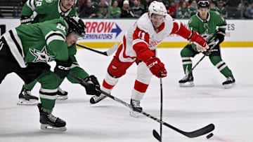 Jan 19, 2025; Dallas, Texas, USA; Dallas Stars right wing Matej Blumel (25) pokes the puck away from Detroit Red Wings right wing Vladimir Tarasenko (11) during the first period at the American Airlines Center. Mandatory Credit: Jerome Miron-Imagn Images