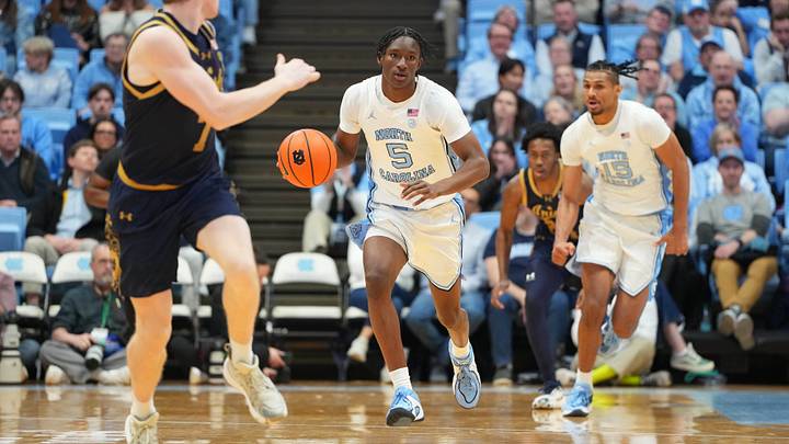 Jan 21, 2026; Chapel Hill, North Carolina, USA; North Carolina Tar Heels guard Isaiah Denis (5) with the ball as Notre Dame Fighting Irish forward Ryder Frost (7) defends in the second half at Dean E. Smith Center. Mandatory Credit: Bob Donnan-Imagn Images