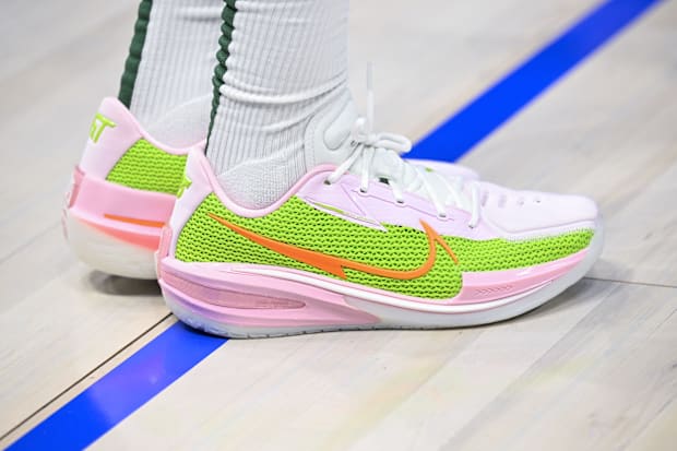 Boston Celtics guard Jrue Holiday wears pink and orange Nike sneakers.