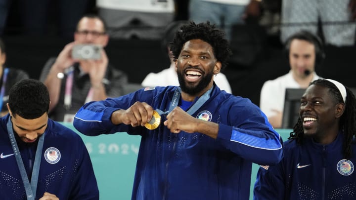 Aug 10, 2024; Paris, France; United States centre Joel Embiid (11) celebrates with the gold medal on the podium after defeating France in the men's basketball gold medal game during the Paris 2024 Olympic Summer Games at Accor Arena. Mandatory Credit: Rob Schumacher-USA TODAY Sports