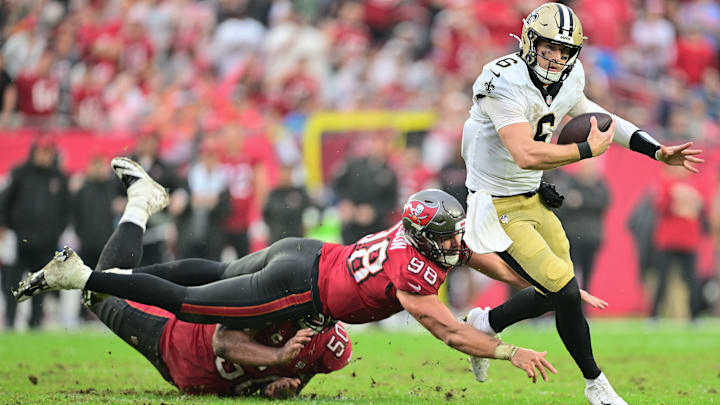 New Orleans Saints QB Tyler Shough (6) runs away from Tampa Bay Bucs OLB Anthony Nelson (98) and DT Vita Vea (50) on Dec. 7, 2025.